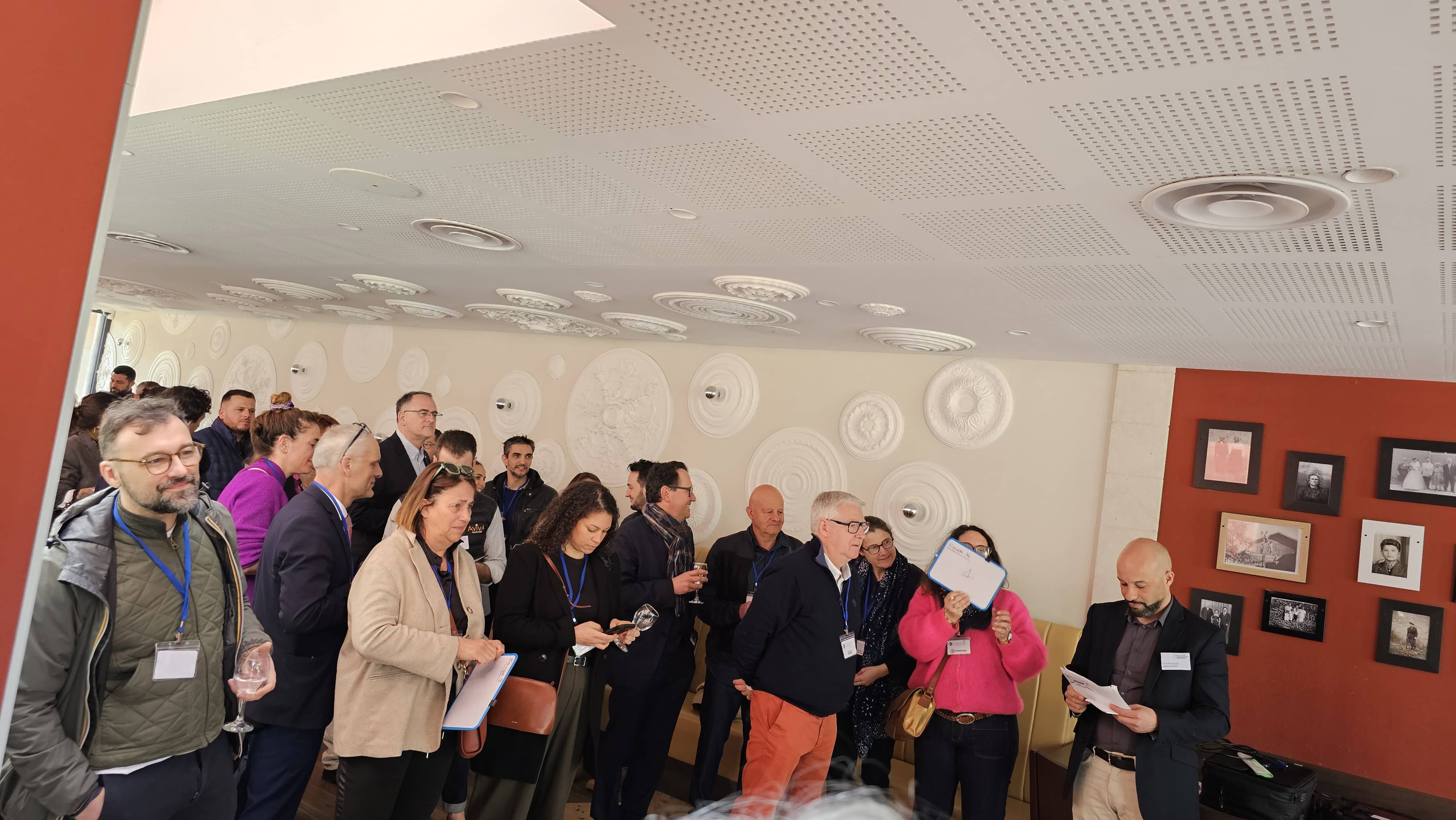 Invités lors d'une réception privée chez Fabioli, sous le plafond aux médaillons de plâtre et le mur de photos de famille