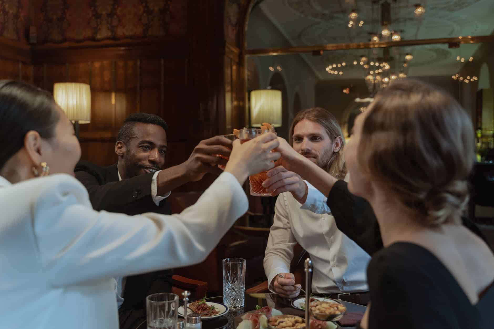 Tablée d'amis trinquant lors d'un repas de groupe convivial au restaurant